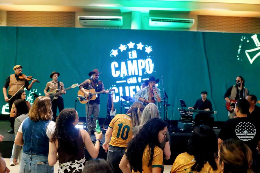 Banda no palco do evento Em Campo com o Cliente da ADM, com o público dançando