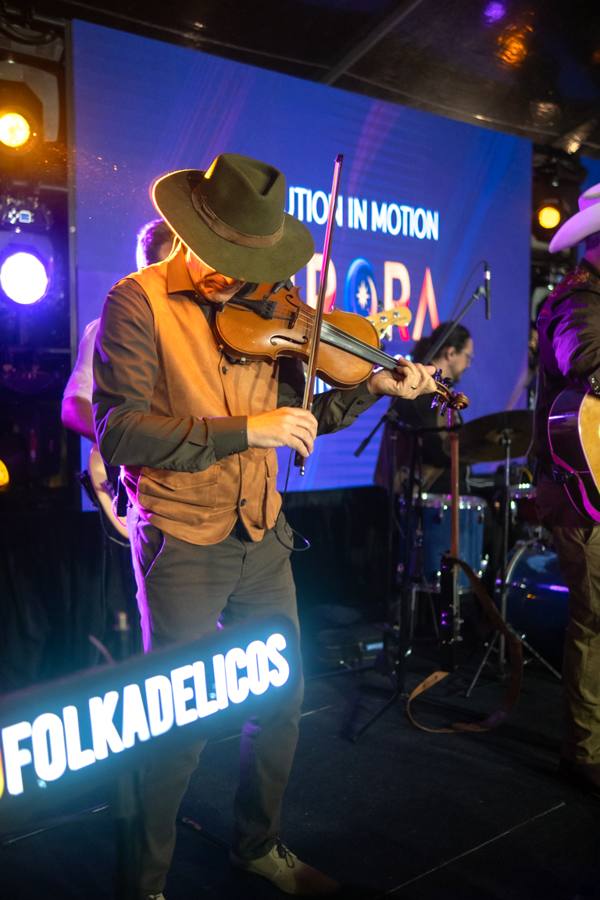 Violinista com o letreiro Folkadelicos e o telão do Aurora Summit