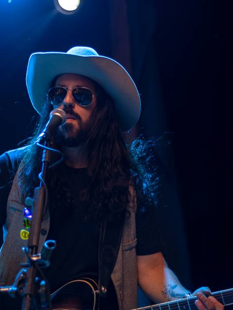 Guitarrista dos Folkadelicos de chapéu e óculos escuros