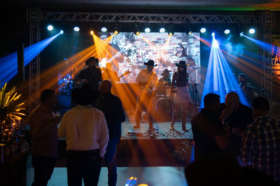 Luzes de show sobre o palco e convidados no evento da Agro Piatã