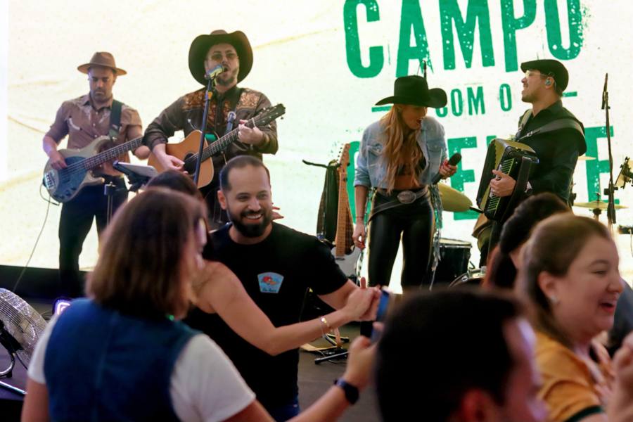 Banda tocando e público dançando no evento da ADM